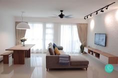 a living room filled with furniture and a flat screen tv on top of a wooden table