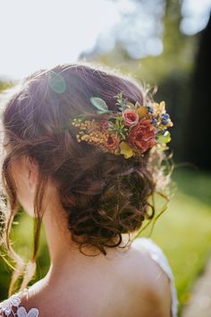 a woman with flowers in her hair looking off into the distance while wearing a flower crown