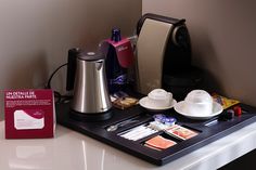 the coffee maker is sitting on top of the counter next to other items that have been placed around it