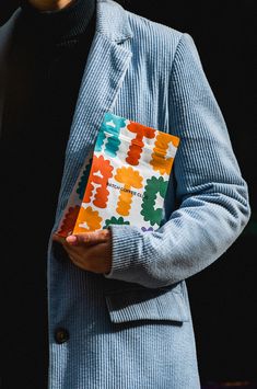 a man in a blue jacket holding a colorful piece of paper