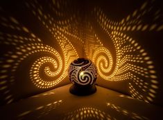 a decorative vase sitting on top of a table next to a wall with intricate designs