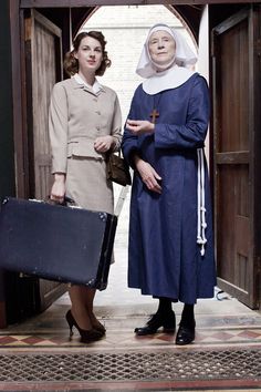 two women are standing outside with their luggage