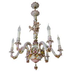 an ornate chandelier with pink flowers and angel figurines