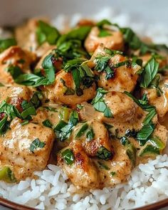 a white plate topped with rice and chicken on top of green leafy garnish