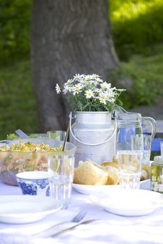 the table is set with food and drinks for two people to enjoy in the sun