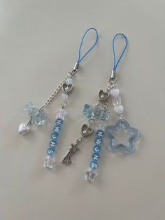 two blue and white charms are hanging from chains