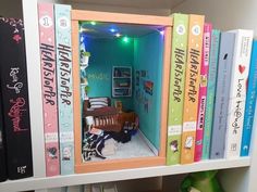 a book shelf filled with lots of books and a doll house in the corner on top of it