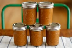 four jars filled with peanut butter sitting on top of a table