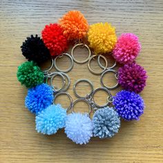 a bunch of pom - poms arranged in a circle on a wooden table