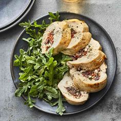 a plate topped with sliced chicken and greens