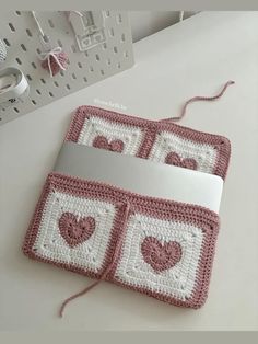 two crocheted purses sitting on top of a white table next to a laptop computer