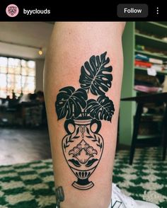 a black and white photo of a vase with plants in it on the leg,