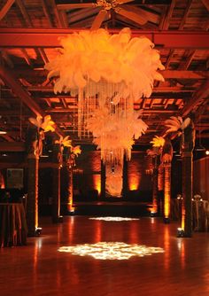 an empty dance floor with chandeliers hanging from the ceiling