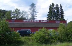 a car parked in front of a red building with a sign that says north shore market