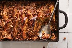 a casserole dish with meat in it and a spoon resting on the side