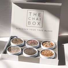 the chai box is filled with different types of teas and seasonings in white bowls