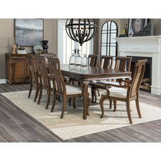 a dining room table and chairs in front of a fireplace