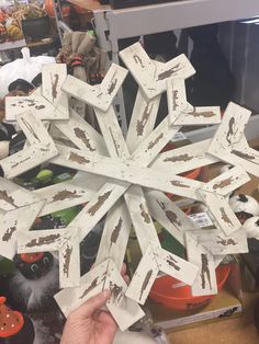 a snowflake made out of white cardboard sitting on top of a wooden table