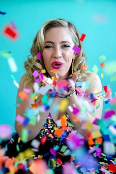 a woman sitting on the ground surrounded by confetti