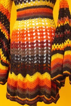 a crocheted sweater is displayed on a mannequin