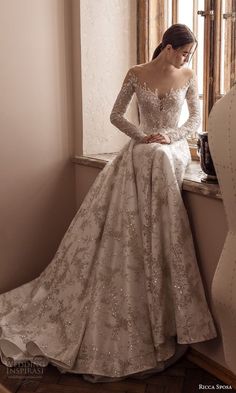 a woman in a wedding dress sitting on a window sill looking out the window