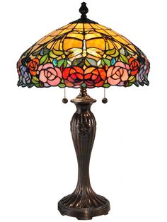 a lamp that is sitting on top of a table with a flower design on it