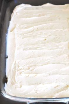 a pan filled with white frosting sitting on top of a counter