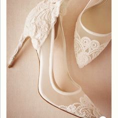 a pair of white shoes with lace on them