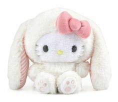 a white stuffed animal with a pink bow on it's head and ears, sitting in front of a white background