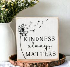 a wooden sign that says, kindness always matters with a dandelion on it