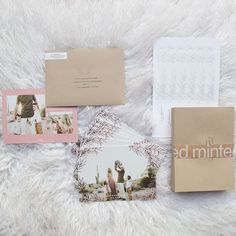 the wedding stationery is laid out on a white furnishing with photos and envelopes