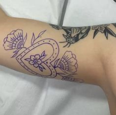 a woman's arm with tattoos on it and flowers in the middle of her arm