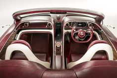 the interior of a car with red leather and white trims, including steering wheel