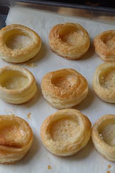 small pastries sitting on top of a white paper lined baking sheet, ready to be baked