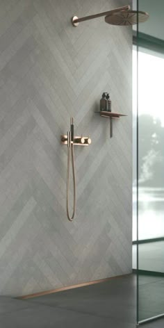 a bathroom with a shower head, hand held shower faucet and tiled walls