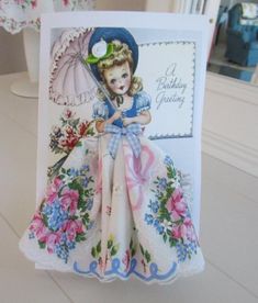 a birthday card with a doll holding an umbrella