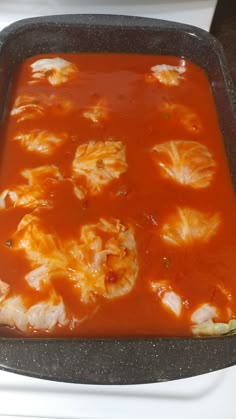 a pan filled with food sitting on top of a stove