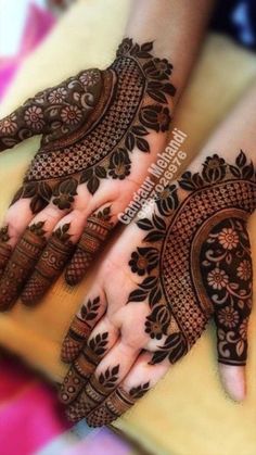 two hands with henna designs on them