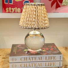 a lamp sitting on top of a book next to a lamp shade that reads chateau life