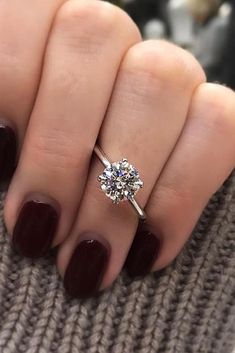 a woman's hand with a ring on it and a diamond in the middle