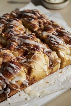 cinnamon roll with icing sitting on top of paper