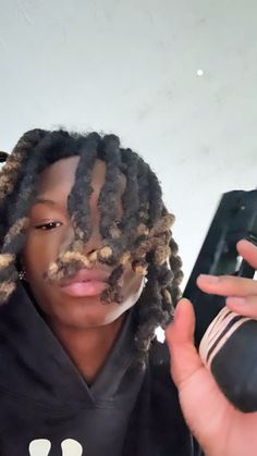 a person with dreadlocks holding a cell phone