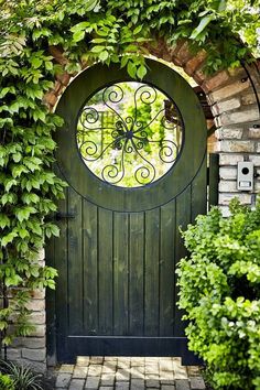 an arched wooden door surrounded by greenery