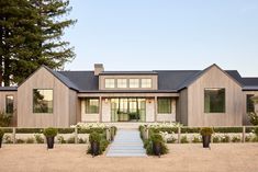 a large house with lots of windows and plants in the front yard