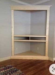 an empty room with some shelves in the corner and a rug on the floor next to it