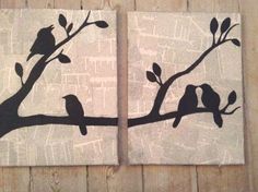 two birds sitting on a branch with leaves painted on them, one is black and the other is white