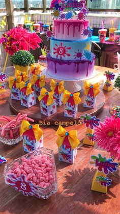 a table topped with lots of colorful cakes and candy