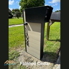 a mailbox sitting in the middle of a grassy area next to a wooden fence