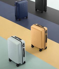 three pieces of luggage sitting on top of a multicolored floor next to each other