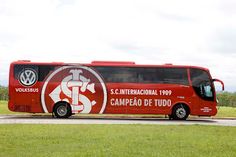 a red bus is parked on the side of the road in front of some grass